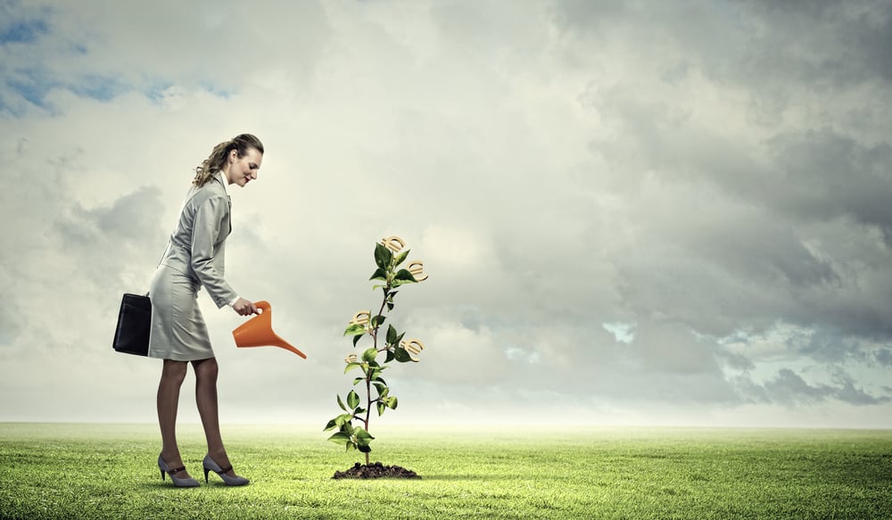 Image of business woman watering money tree. Currency concept