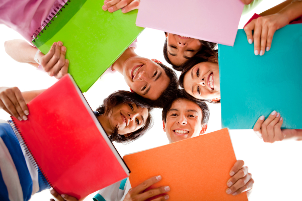 Happy group of students holding notebooks - isolated over white Happy group of students holding notebooks - isolated over white